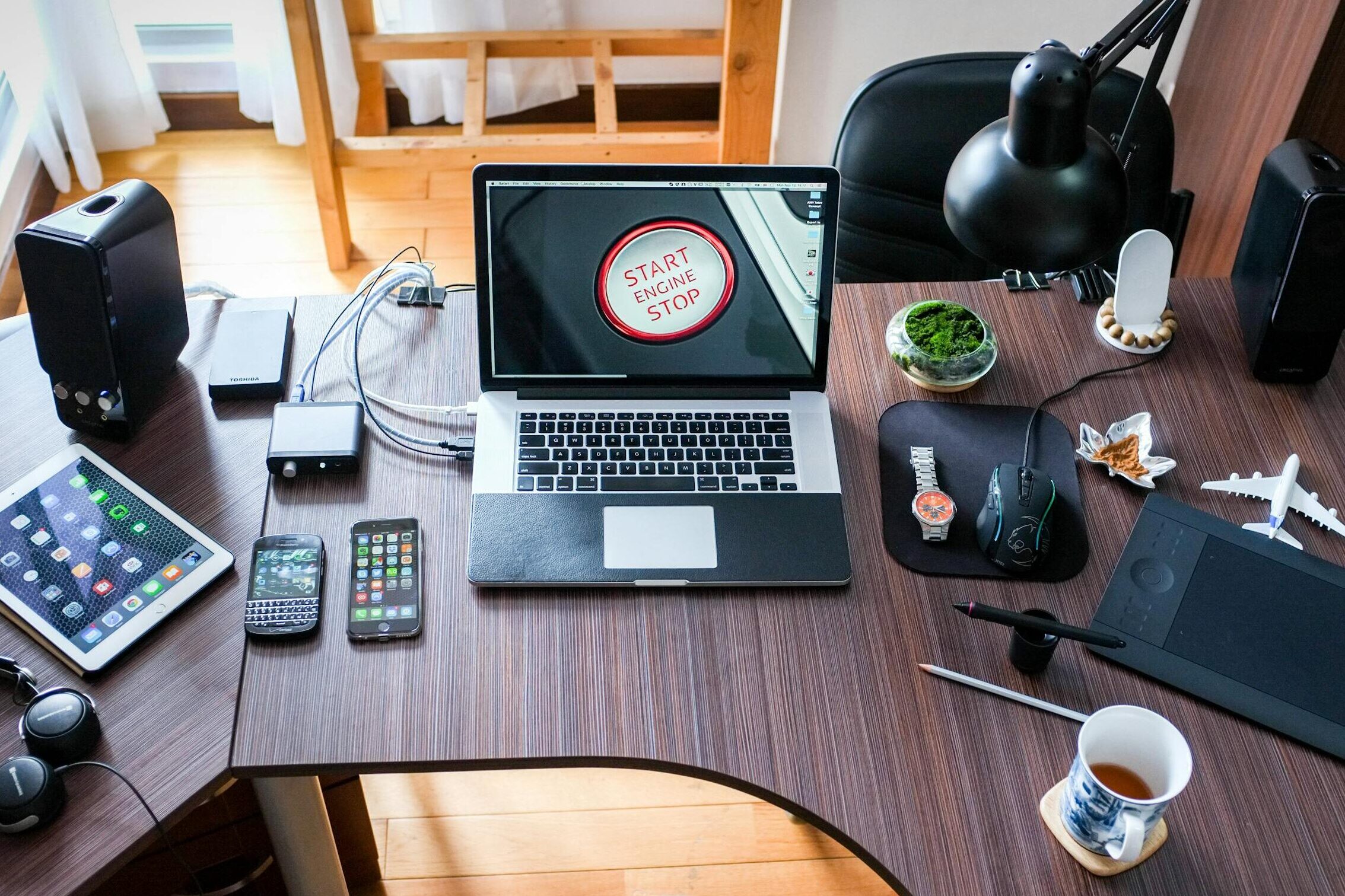 A contemporary office desk setup with laptops, gadgets, and accessories, creating a tech-savvy workplace.